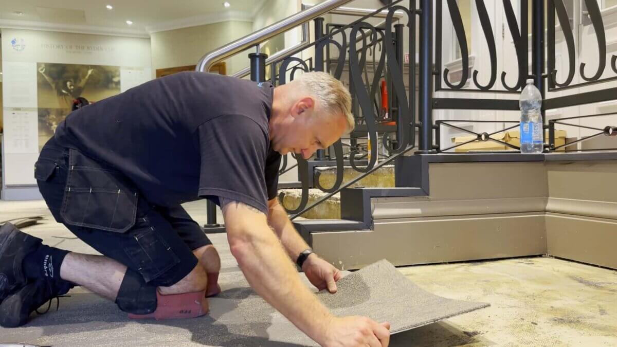 Mark laying Milliken carpet tiles at The Belfry